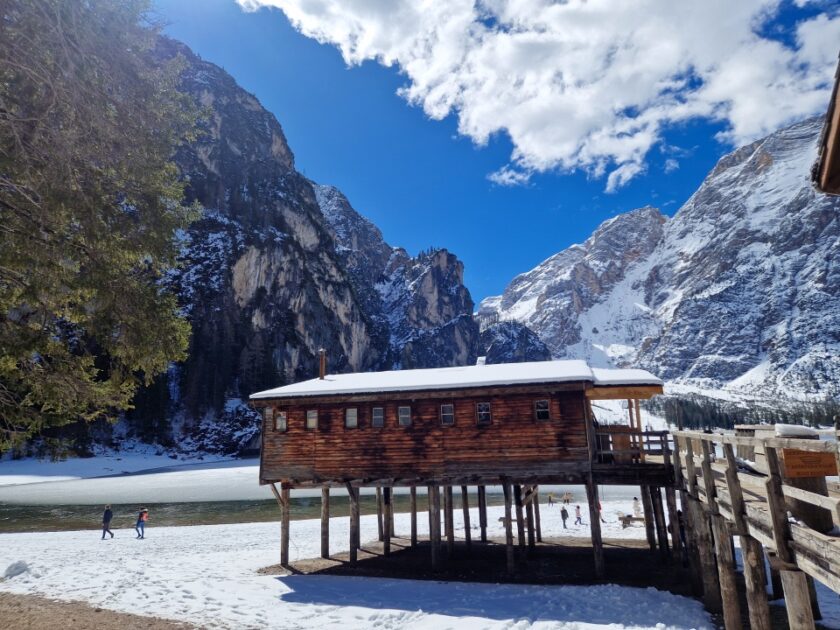 2 días en los Dolomitas en abril: itinerario perfecto y guía del clima braies boat house Cobertizo de botes junto al lago de Braies, con montañas, cielo azul, aguas verdes y mucha nieve, en los Dolomitas en abril