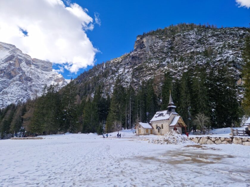 2 días en los Dolomitas en abril: itinerario perfecto y guía del clima braies church Una iglesita encantadora, montañas, árboles y nieve en el lago de Braies, Dolomitas, Italia