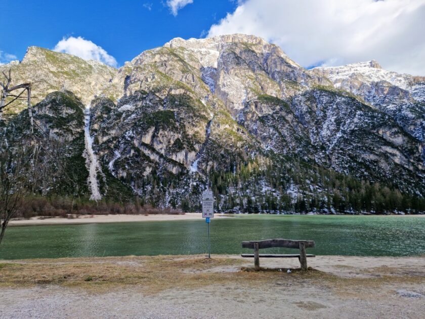 2 días en los Dolomitas en abril: itinerario perfecto y guía del clima lago di landro bench Un banco junto al lago di Landro, de color verde turquesa, con montañas al fondo, en los Dolomitas, Italia