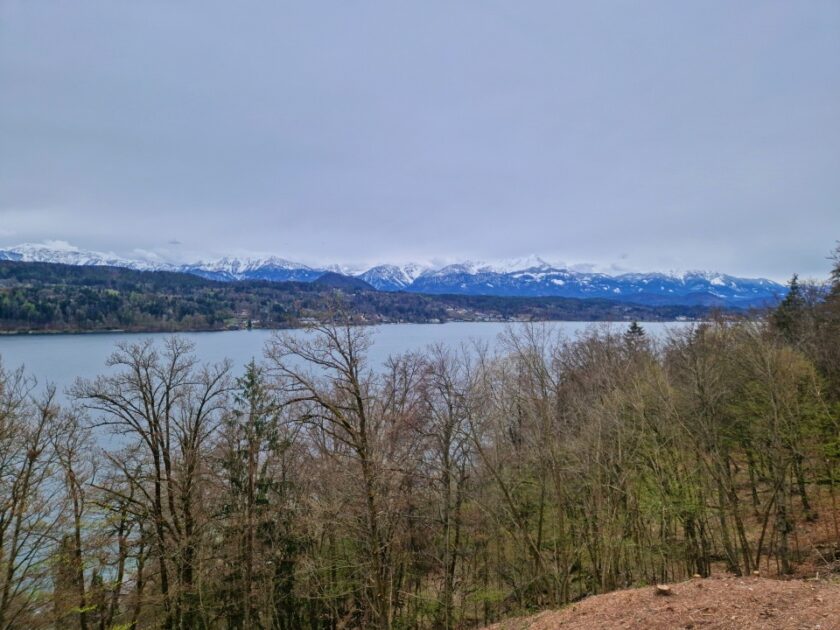 2 días en los Dolomitas en abril: itinerario perfecto y guía del clima lake worthersee El lago Wörthersee, en Austria, de camino a los Dolomitas, con montañas nevadas al fondo