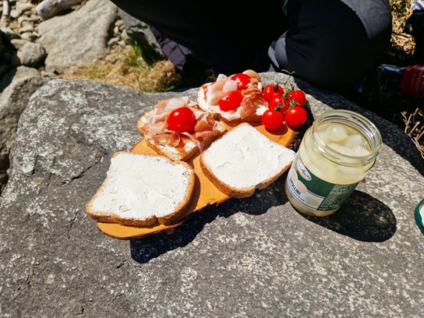 2 días en los Dolomitas en abril: itinerario perfecto y guía del clima valdaora lunch Sándwiches, jamón, tomates y cebollas encurtidas junto al lago de Valdaora, Dolomitas, Italia
