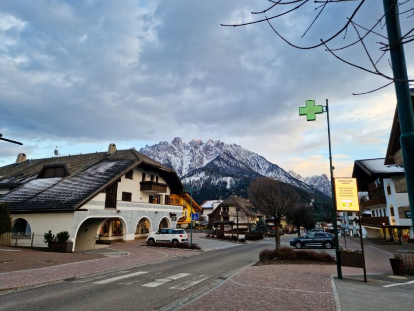 2 días en los Dolomitas en abril: itinerario perfecto y guía del clima view from dobbiaco Vista de una calle y montañas en Dobbiaco/Toblach, en los Dolomitas de Italia