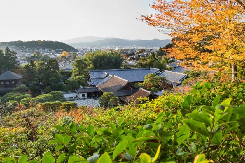 Los mejores lugares para fotos en Kioto: guía de spots instagrameables silver pavillion Ginkaku ji kyoto japan Vista del Pabellón de Plata Ginkaku-ji en Kioto, Japón, con follaje otoñal verde y anaranjado en primer plano